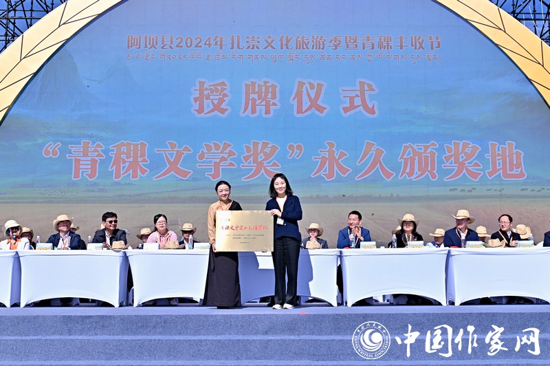 陳亞軍主編代表《民族文學》向阿壩縣授牌，紅梅部長接牌。