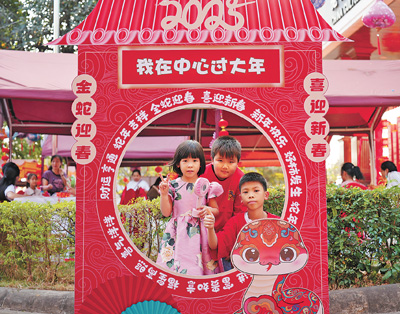 老撾民眾在“歡樂春節”廟會現場設立的新春祈福打卡點拍照。  坎帕頌攝
